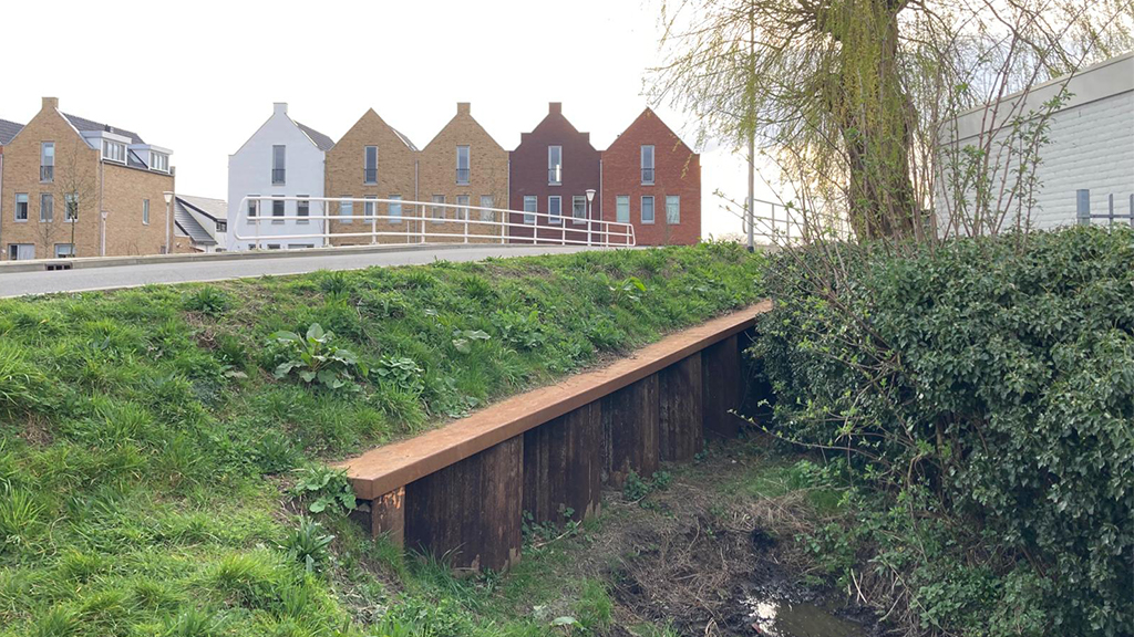 Man in scootmobiel rijdt van stijle talud in Leimuiden