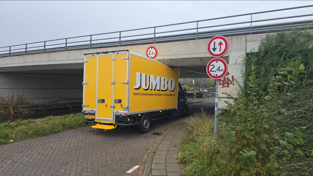 Jumbo-busje komt vast te zitten onder viaduct